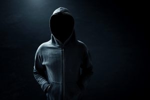 Hacker standing alone in dark room